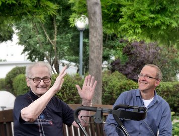 Bewohner auf der Bank draußen unterhält sich mit Personal
